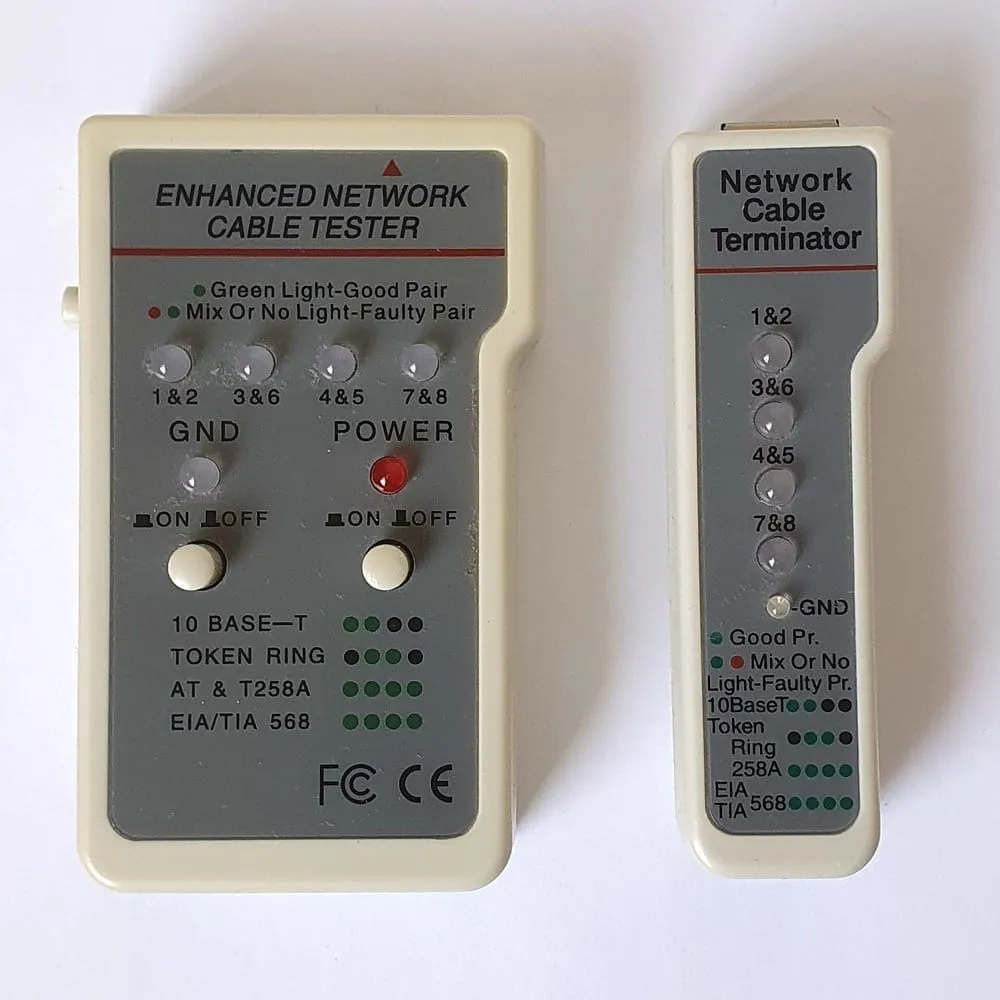 A two-piece network cable tester on a white background. The larger unit is labelled ENHANCED NETWORK CABLE TESTER and has four indicator lights labelled 1 and 2, 3 and 6, 4 and 5, 7 and 8, with a legend reading green light good pair, mix or no light faulty pair. The smaller unit is a remote terminator with the same four labels.